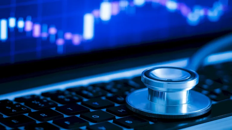 IA da Microsoft - Estetoscópio sobre teclado de laptop com gráficos azuis ao fundo, representando tecnologia e saúde.